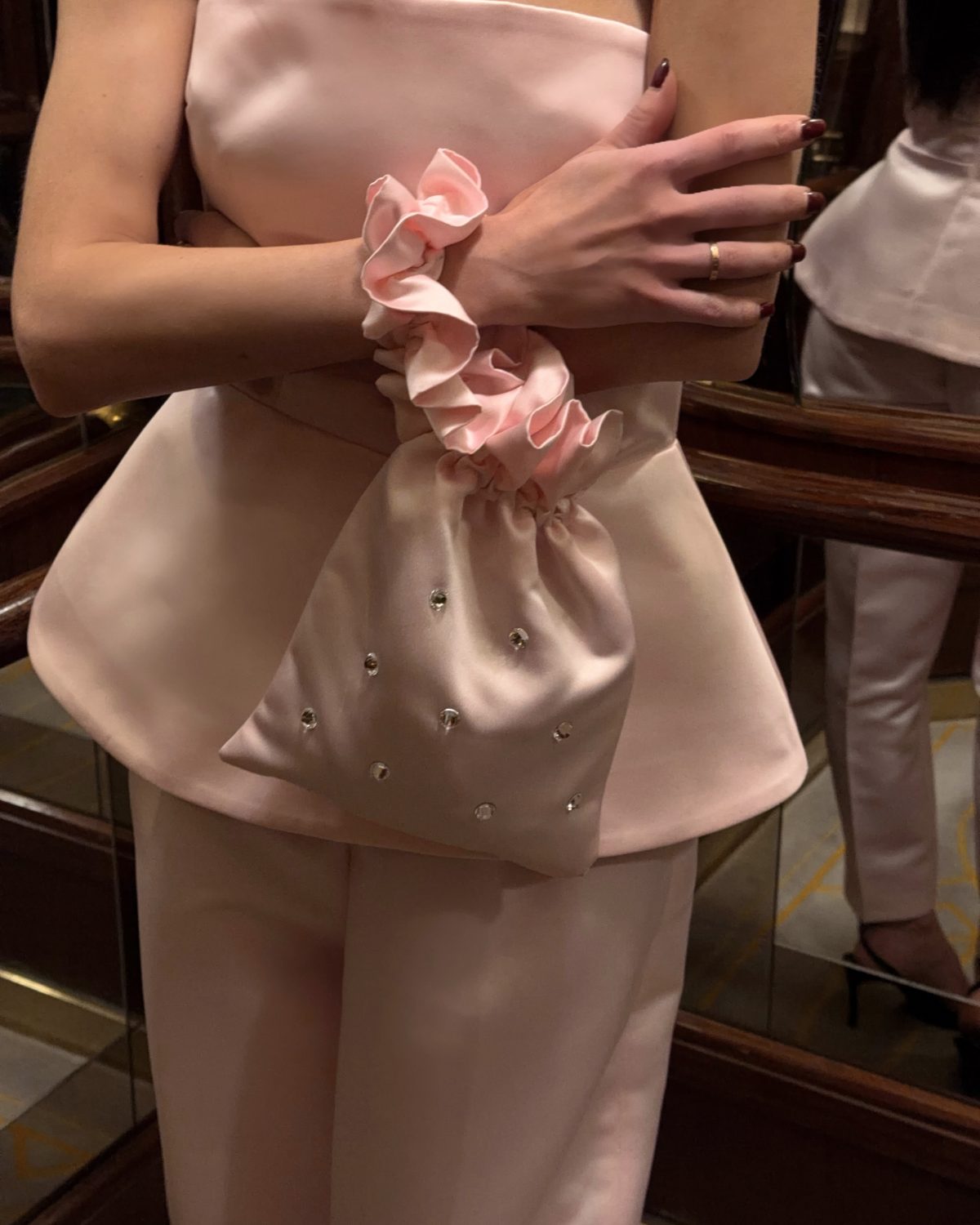 Девушка в розовом атласном топе и брюках