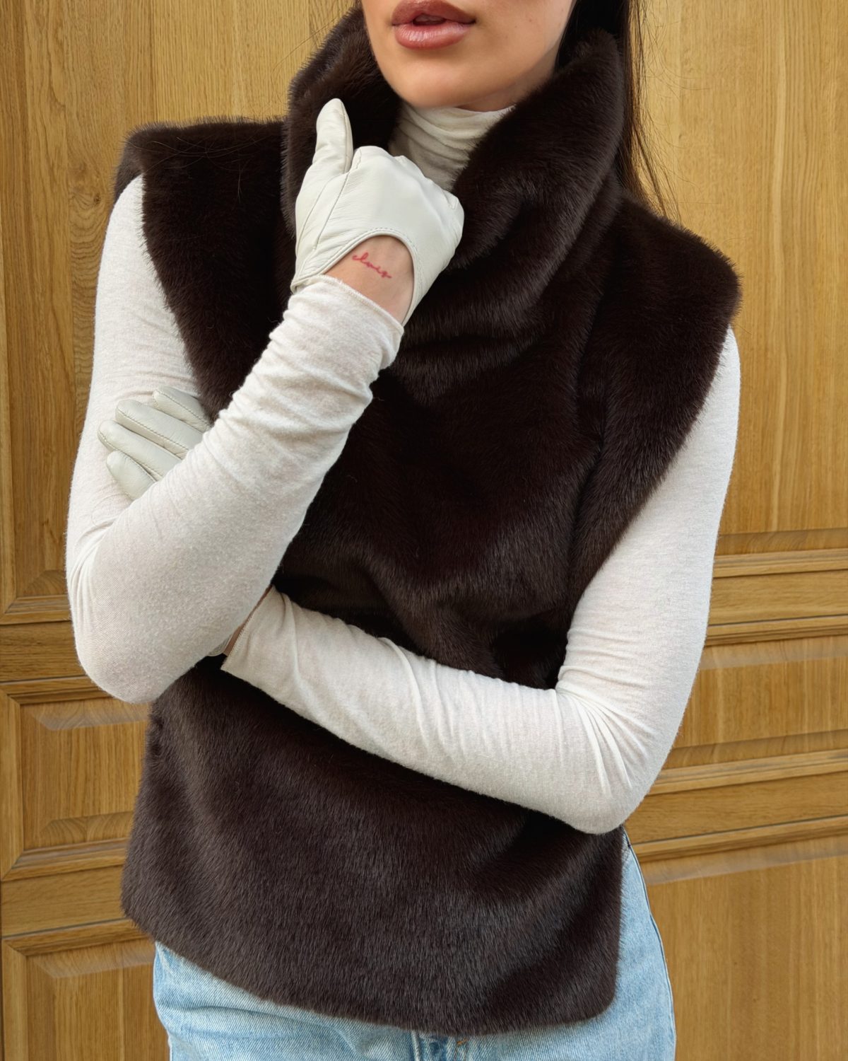 Девушка в манишке из искусственного меха шоколадного цвета