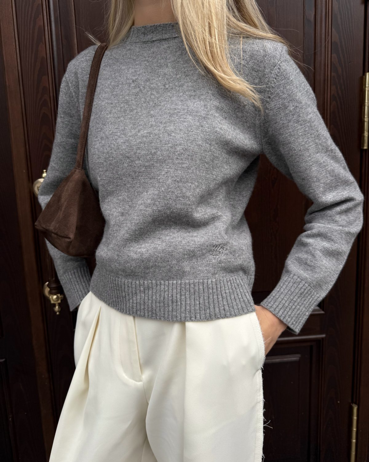 Девушка в сером свитере и брюках молочного цвета