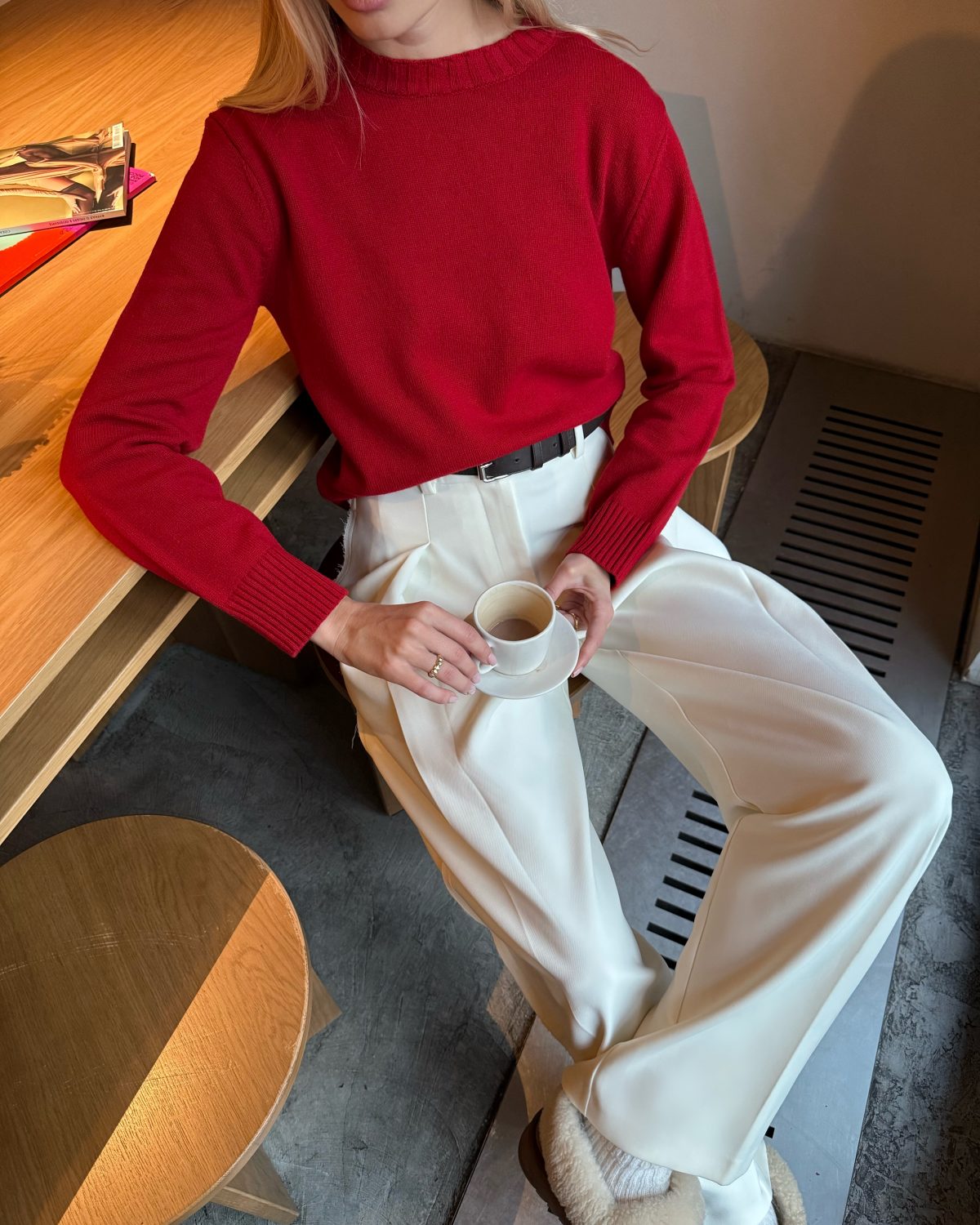 Девушка в красном свитере и брюках молочного цвета