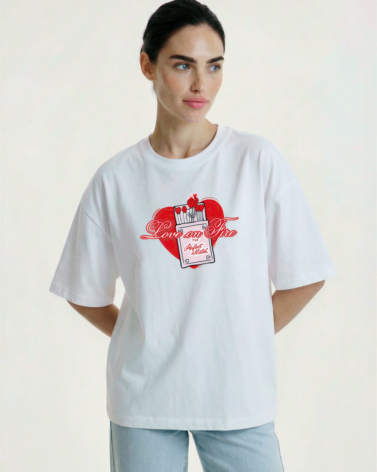 Девушка в белой футболке оверсайз с принтом love on fire